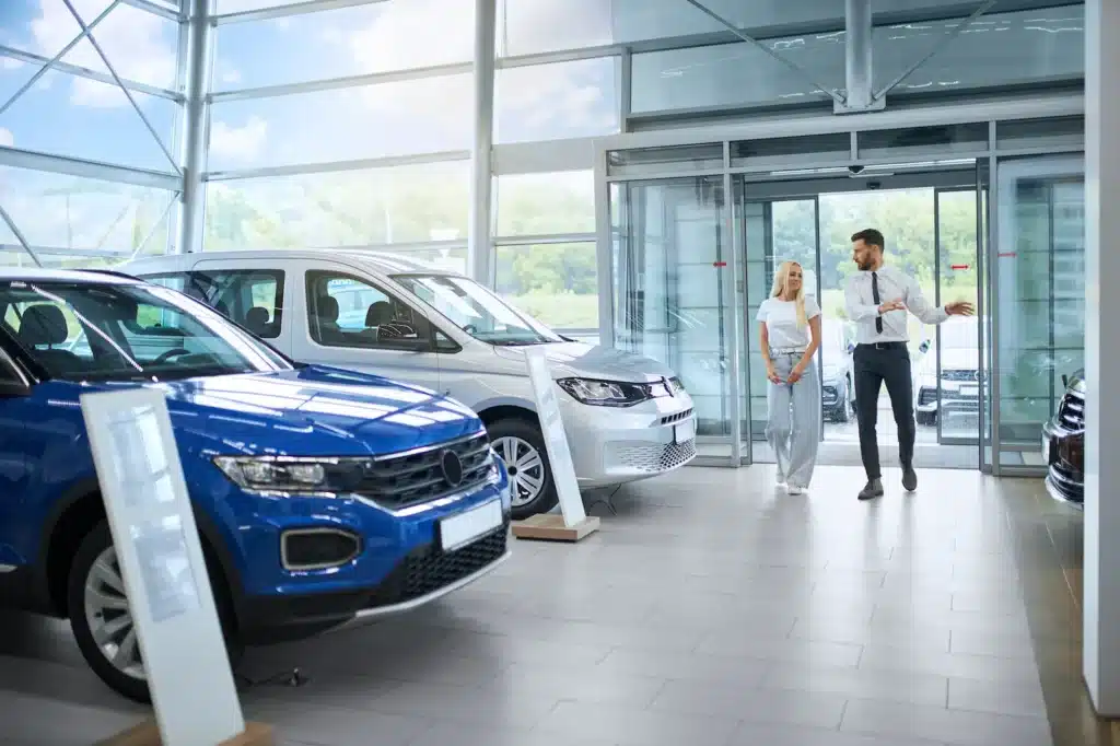 Car dealership showroom with customers and vehicles